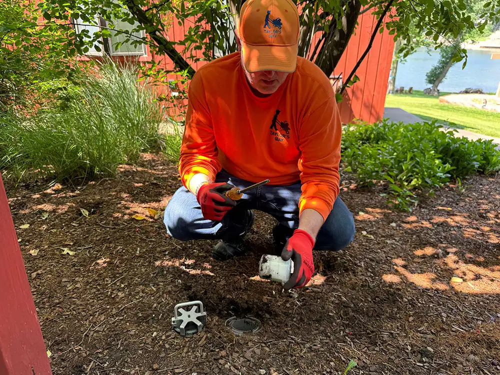 Technician installing a discreet termite bait station