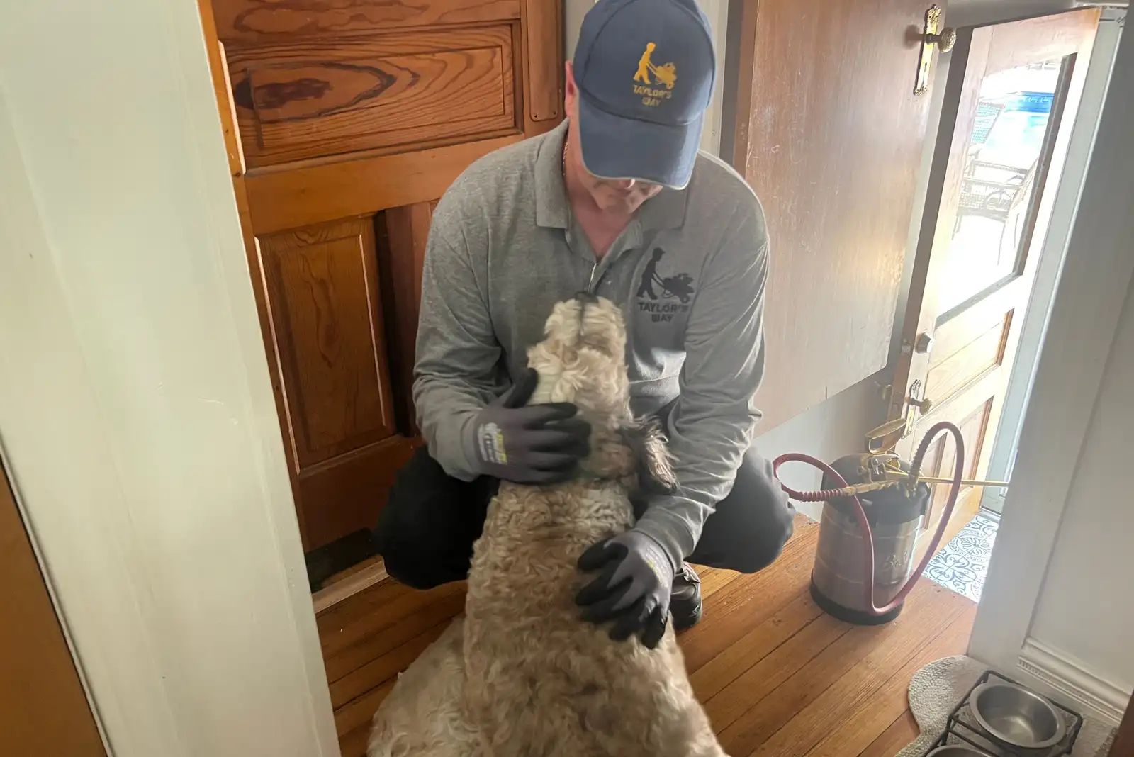 Taylor’s Way technician greeting a family dog inside a customer’s home